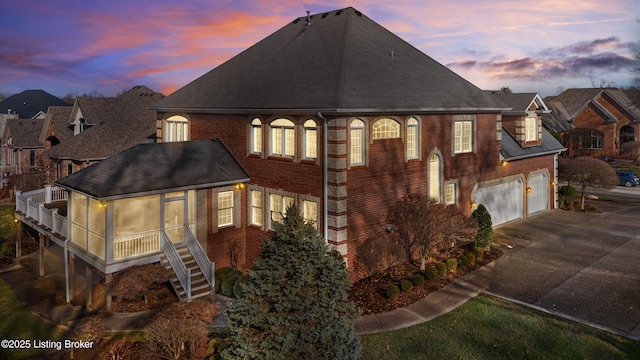 property exterior at dusk featuring a sunroom and a garage