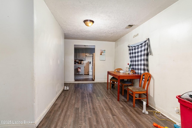 dining room featuring a textured ceiling and dark wood-type flooring