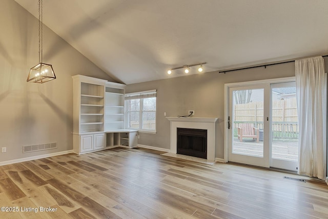 unfurnished living room with vaulted ceiling, light hardwood / wood-style flooring, and plenty of natural light