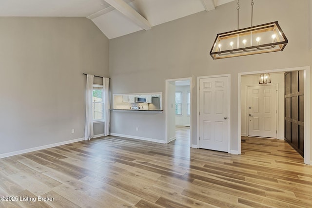 unfurnished living room with hardwood / wood-style flooring, beamed ceiling, and high vaulted ceiling