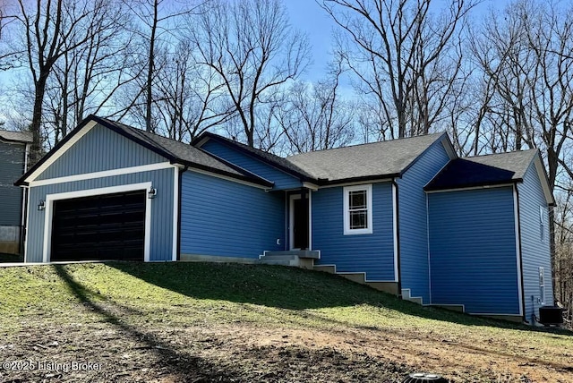 ranch-style home featuring a garage, central AC, and a front lawn