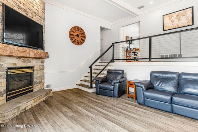 living room featuring a fireplace, light wood-type flooring, and crown molding