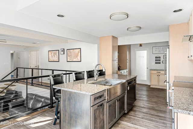 kitchen with light stone countertops, sink, hardwood / wood-style floors, and black dishwasher