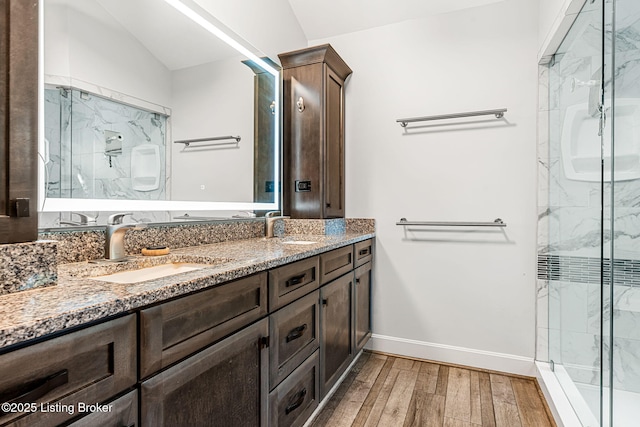 bathroom featuring hardwood / wood-style floors, vanity, a shower with shower door, and lofted ceiling