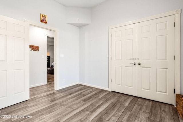 unfurnished bedroom featuring light hardwood / wood-style flooring and a closet