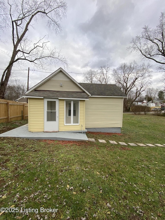 back of property with a lawn and a patio area