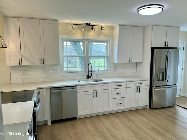 kitchen featuring appliances with stainless steel finishes, white cabinetry, and sink