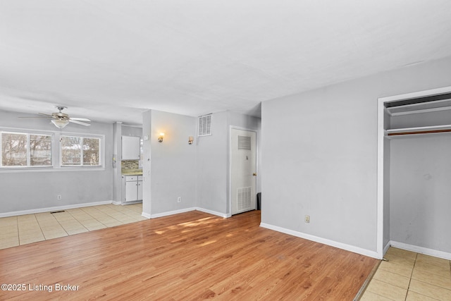 unfurnished living room featuring ceiling fan and light hardwood / wood-style flooring