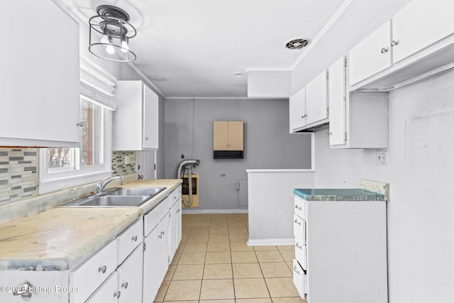 kitchen with crown molding, sink, white cabinetry, light tile patterned flooring, and tasteful backsplash