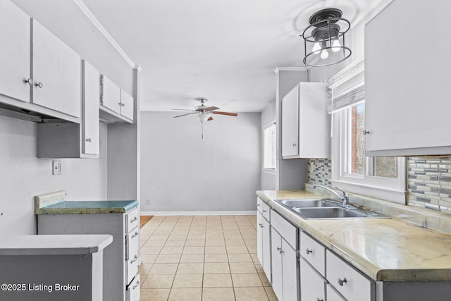 kitchen with light tile patterned floors, decorative backsplash, white cabinetry, ceiling fan, and sink