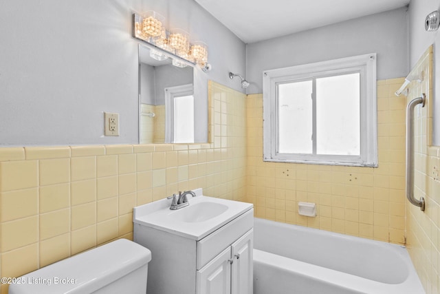 full bathroom with toilet, tiled shower / bath, tile walls, and vanity