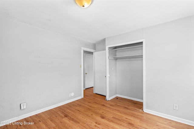 unfurnished bedroom with a closet and light wood-type flooring