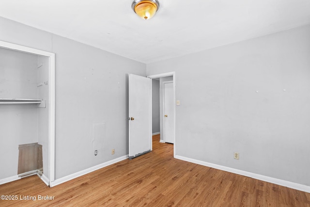 unfurnished bedroom with light wood-type flooring and a closet