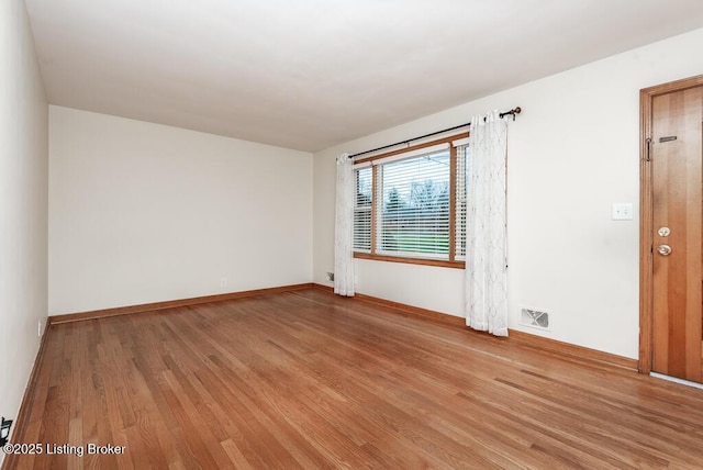 empty room with light hardwood / wood-style flooring