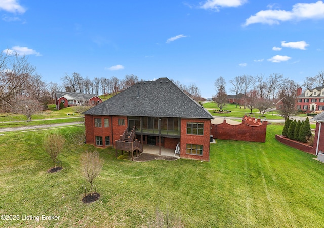 back of house featuring a sunroom, a patio area, and a lawn