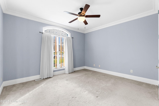 unfurnished room with ceiling fan, light colored carpet, and crown molding