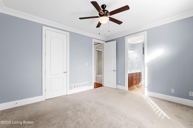 unfurnished bedroom featuring ensuite bathroom, ceiling fan, ornamental molding, and light colored carpet