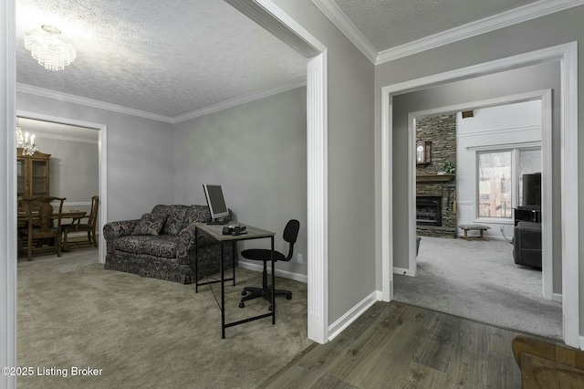 office with dark colored carpet, a notable chandelier, a textured ceiling, a fireplace, and ornamental molding