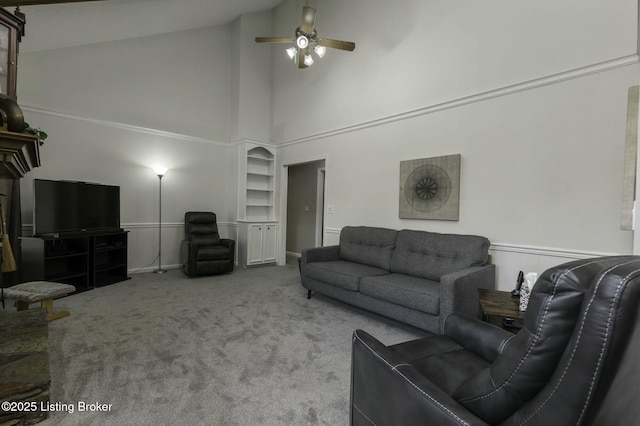 carpeted living room with ceiling fan and high vaulted ceiling