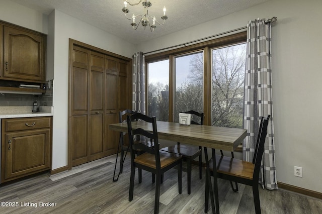 dining space featuring a notable chandelier, dark hardwood / wood-style floors, and a textured ceiling