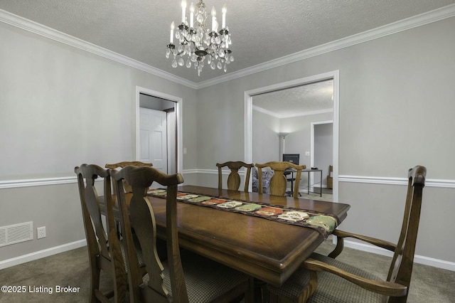 dining area with a chandelier, a textured ceiling, dark carpet, and ornamental molding