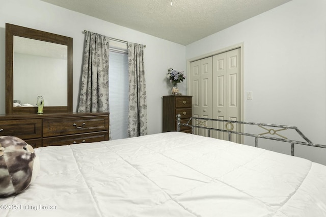 bedroom with a textured ceiling and a closet