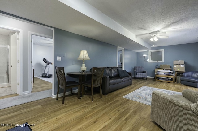 living room featuring hardwood / wood-style floors, a textured ceiling, and ceiling fan