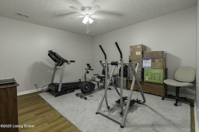 workout area featuring hardwood / wood-style floors, a textured ceiling, and ceiling fan