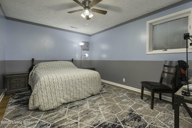 bedroom with ceiling fan and a textured ceiling