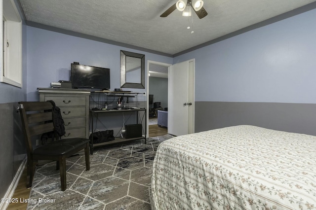 bedroom featuring ceiling fan and a textured ceiling