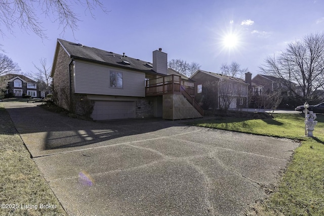 view of side of home with a yard, a garage, and a deck