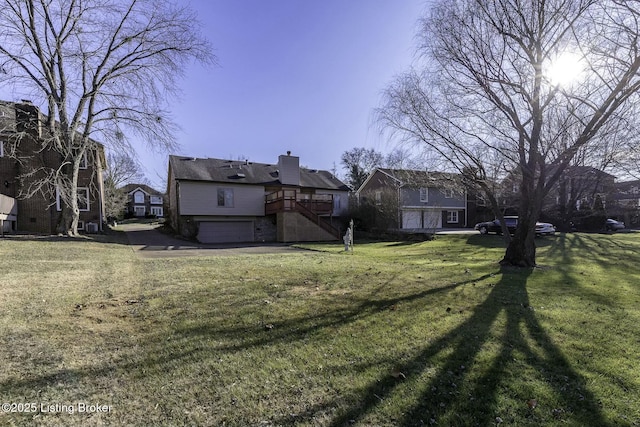 view of yard featuring a garage and a wooden deck