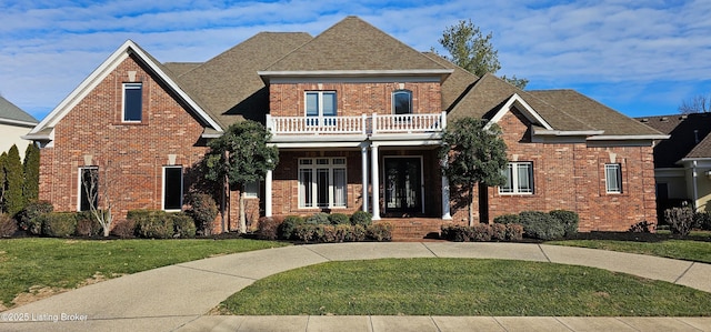 view of front of property featuring a balcony and a front lawn