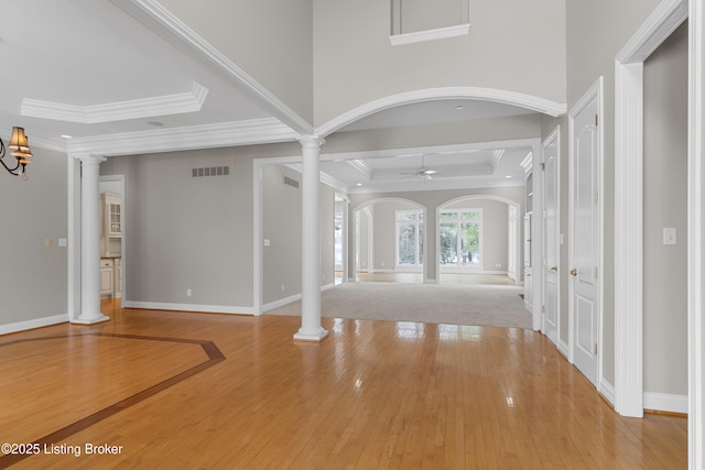 foyer featuring hardwood / wood-style floors, ceiling fan, and decorative columns