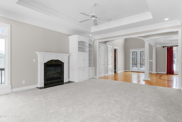 unfurnished living room with a fireplace, french doors, ceiling fan, and ornamental molding