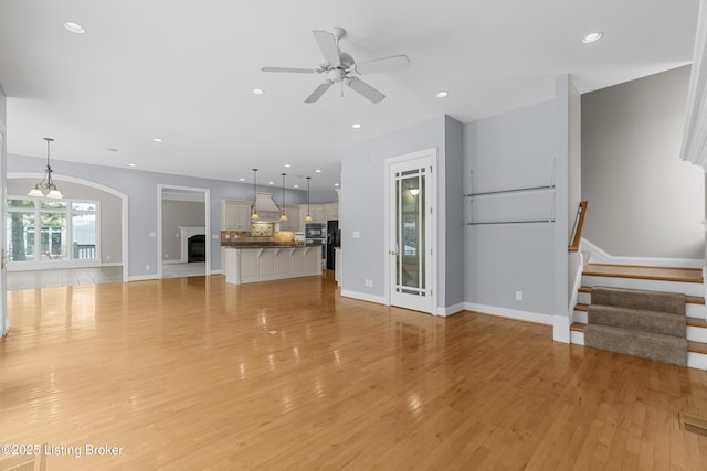 unfurnished living room with ceiling fan and light hardwood / wood-style flooring