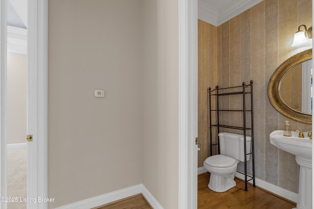 bathroom featuring hardwood / wood-style floors, toilet, and ornamental molding