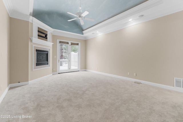 unfurnished living room with ornamental molding, light colored carpet, vaulted ceiling, a raised ceiling, and ceiling fan