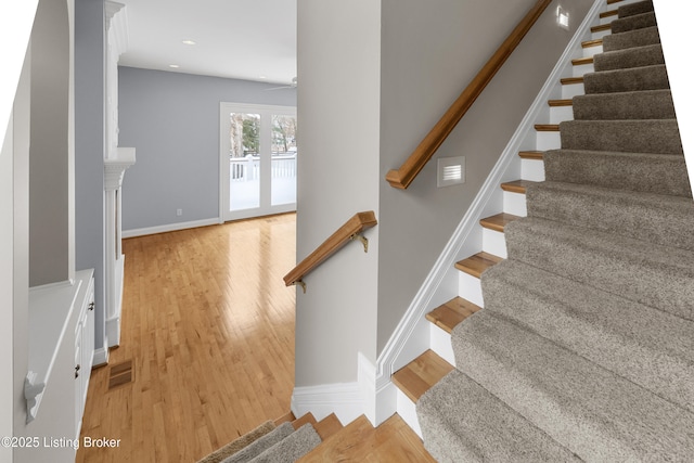 staircase with ceiling fan and hardwood / wood-style flooring