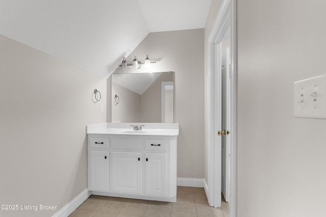 bathroom with tile patterned floors, vanity, and vaulted ceiling