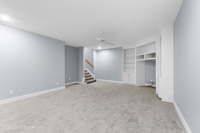 interior space with carpet flooring, built in shelves, and ceiling fan