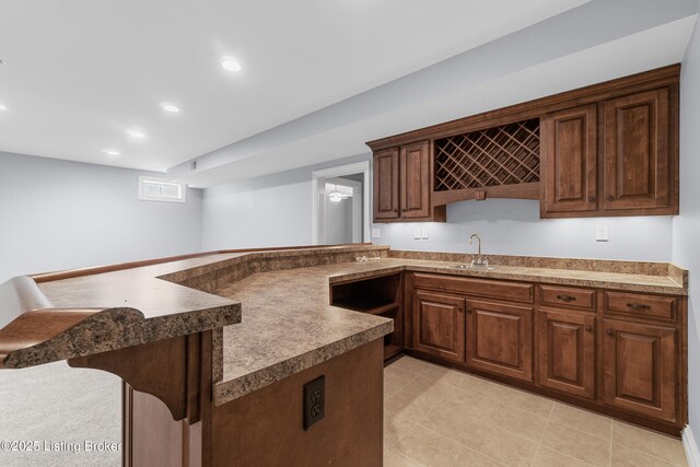 kitchen with a kitchen breakfast bar, kitchen peninsula, and sink