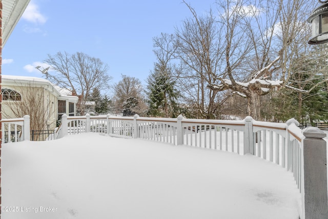 yard covered in snow featuring a deck