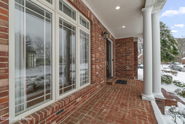 snow covered patio with a porch