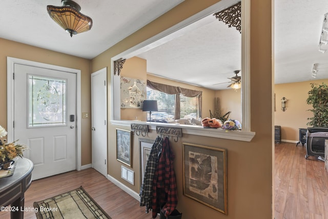 entryway featuring a textured ceiling, hardwood / wood-style flooring, and ceiling fan