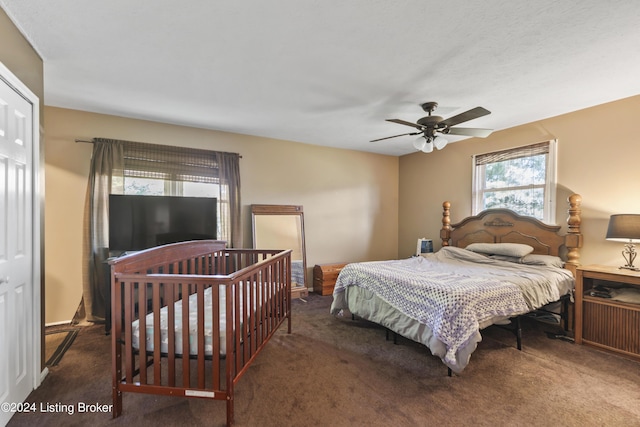 bedroom with dark colored carpet and ceiling fan