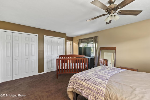 carpeted bedroom featuring ceiling fan and multiple closets