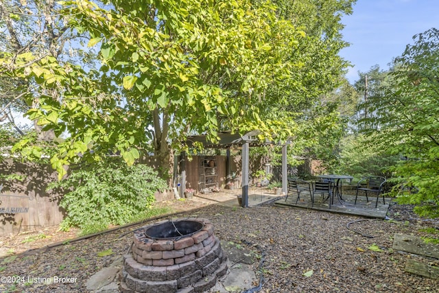 view of yard featuring a deck and an outdoor fire pit