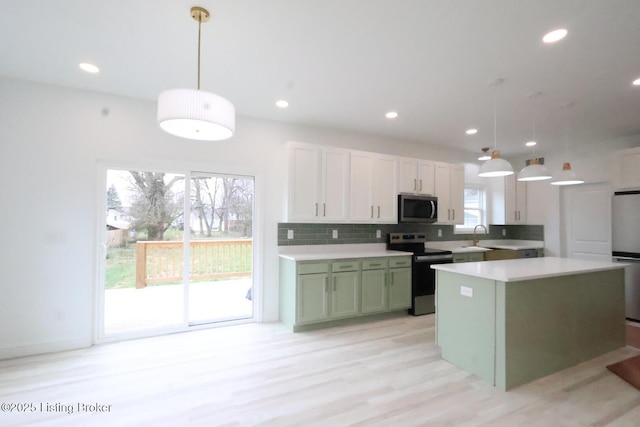 kitchen featuring decorative backsplash, appliances with stainless steel finishes, white cabinetry, hanging light fixtures, and green cabinets