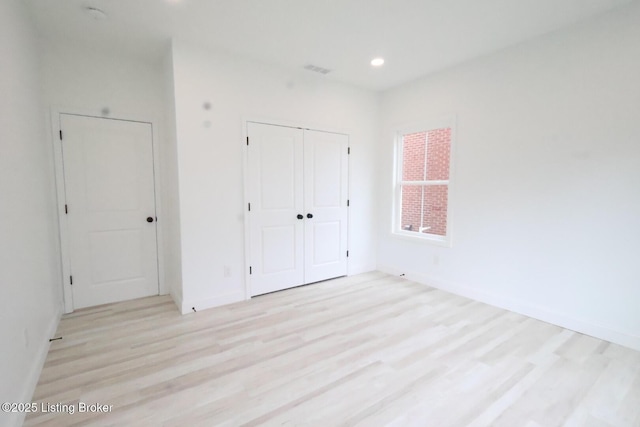 unfurnished bedroom featuring a closet and light hardwood / wood-style floors